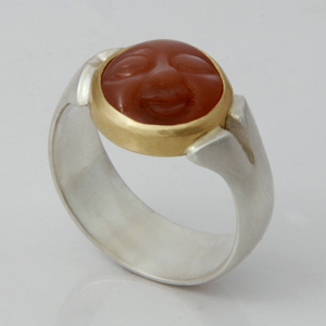  A fluted shank ring in silver and a moon face carved into an Indian moonstone and set in 18K yellow gold